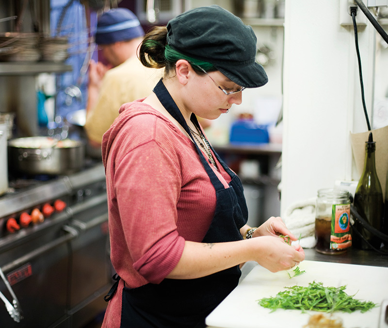 Woman preparing food in restaurant kitchen