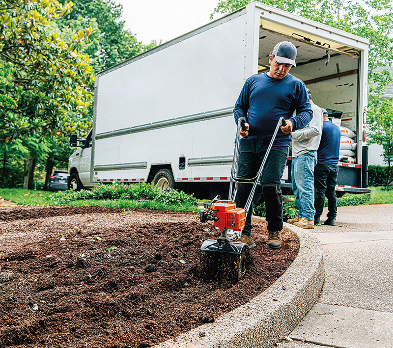 Young Hispanic / Latino Man Using a Rotary Tiller Machine