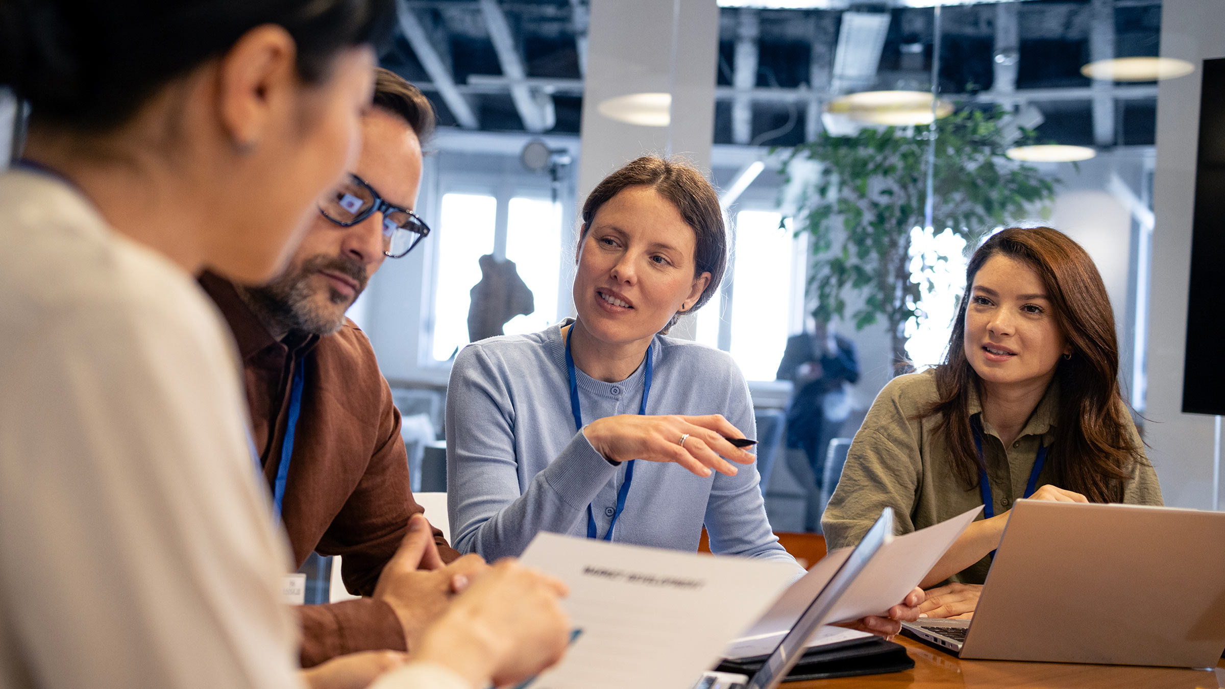 Consultants gathered around a table discussing charts.